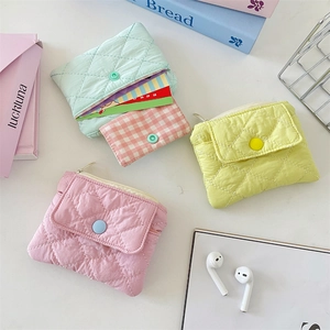Close-up of quilted card holder wallets in macaron colors with snap and zipper closure