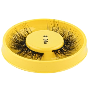 Close-up of black false eyelashes in a round yellow case labeled #104A with white background