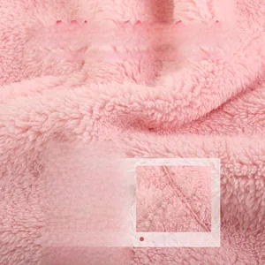 Detail of pink double-sided plush fabric showing soft warm texture and neat stitching