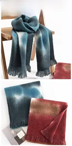 Detailed close-up of thick cashmere-like scarf with paisley print and fringe tassels