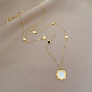Gold titanium steel necklace with white shell pendant on champagne silk background