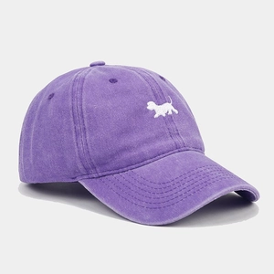 Dettaglio del cappello da baseball in cotone lavato viola con ricamo a cane bianco di pregio