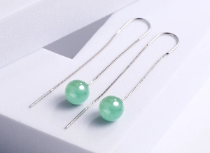 Detail of long silver chain earrings with polished round green aventurine stone beads