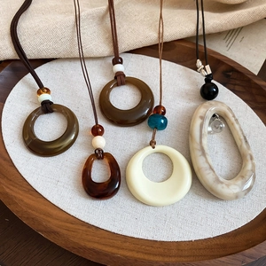 Détails des colliers géométriques en résine acrylique avec textures marbre et ambre