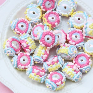 Colorful hand-painted resin beads in a dish for DIY jewelry making and crafts