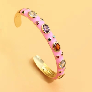 Close-up of pink enamel open bangle with colorful cubic zirconia in gold plating