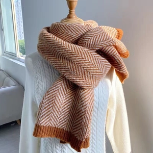 Sciarpa in maglia caramello e beige con motivo a onde esposta su un manichino
