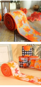 Close-up of autumn ribbon with maple leaf and pumpkin prints on rustic linen texture