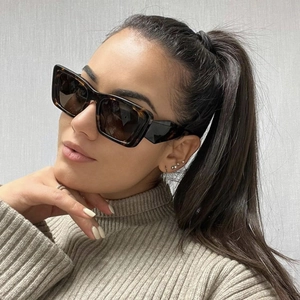 Fashionable tortoise shell rectangular sunglasses worn by model against a neutral background