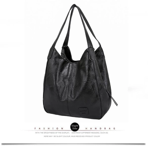 Detail of black pebbled leather tote bag with unique irregular stitching and side logo