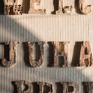 Close-up of wooden letters with natural bark texture for vintage cafe wall decoration