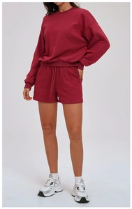 Detail of burgundy lounge set featuring crewneck sweatshirt and drawstring shorts
