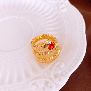 Detail of a vintage gold-plated layered ring featuring a vibrant red pear-cut zircon stone