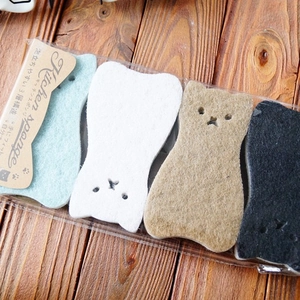 Set of 4 cute cat-shaped kitchen sponges in four colors on a rustic wooden surface