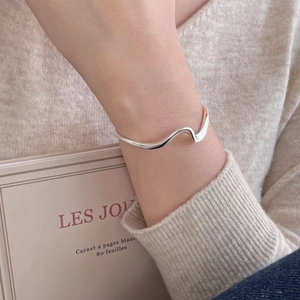 Nahaufnahme des S925 Sterling Silber Mobius Armreifs am Handgelenk einer Frau