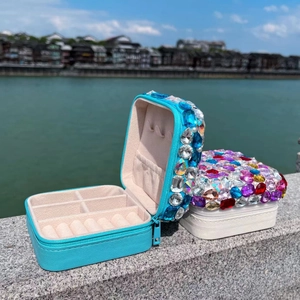 Detail of portable jewelry boxes with luxury rhinestone lids against a scenic river background