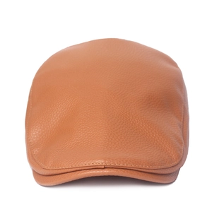 Détail de la texture en cuir marron et des coutures sur une casquette plate classique