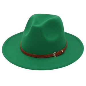 Detail of green felt fedora with brown leather belt and metallic buckle on white background