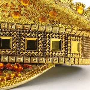 Close-up of gold sequin captain hat with orange gemstones and metallic rivet details
