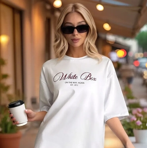 Λεπτομέρεια από λευκό βαμβακερό oversized μπλουζάκι με στάμπα και χαμηλωμένους ώμους