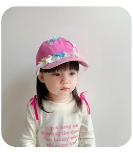 Close-up of pink toddler sun hat with lace trim blue ribbon and pearl details