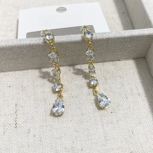 Detail of long teardrop tassel earrings with blue crystals in a luxury jewelry box