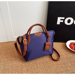 Deep purple nylon tote bag featuring brown leather trim on a textured straw mat