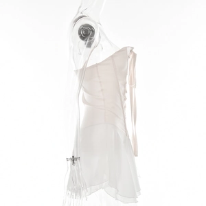 Detail of white strapless dress featuring lace-up back and ruffled hemline