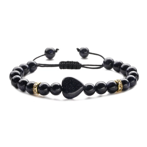 Close-up of heart-shaped blue sandstone bead on an adjustable braided macrame bracelet