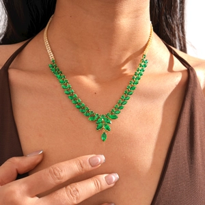 Détail d'un collier luxe en V avec pendentifs épi de blé et pierres marquises vertes