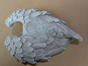 Detailed view of white resin angel wings with intricate feather texture and matte finish