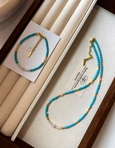 Detail of turquoise and freshwater pearl beaded necklace with 18K gold plated spacers