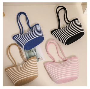 Flat lay of woven shoulder bags in four colors with pearl charms and long handles