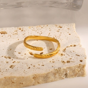 Gold plated stainless steel ring with irregular hammered texture on a stone pedestal
