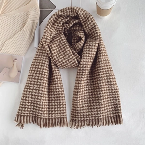 Detailed close-up of brown houndstooth scarf texture with elegant fringe tassels