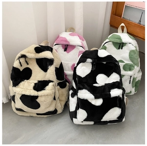 Detail of four colorful faux fur backpacks with heart patterns and soft plush texture
