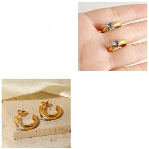 Detail of 18k gold plated C-shaped hoop earrings featuring a heart-shaped zircon crystal