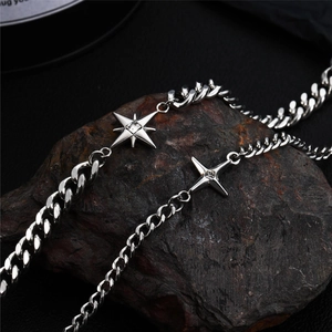Close-up of silver star pendants with clear stones on a chunky metal chain