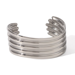 Macro view of wide silver ribbed multi-layer stainless steel bangle bracelet details