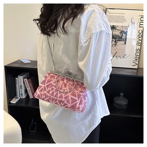 Close-up of pink sequined handbag with diamond handle and silver chain strap details