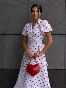 Detail of red heart print wrap dress with puff sleeves and waist tie on white cotton