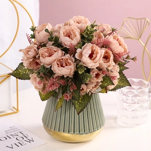 Detailed view of artificial pink peony bouquet in a cyan ceramic vase with gold rim