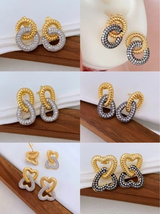 Detail of 18K gold and silver plated earrings with zircon paving on wood and silk