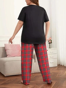 Vista posteriore di una donna con maglia nera e pantaloni del pigiama a quadri rossi