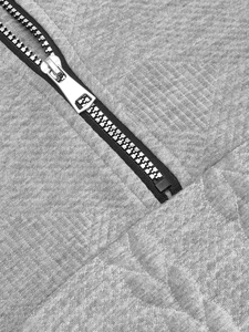 Macro shot of high-quality metal zipper and grey knit texture on a men's quarter-zip sweatshirt