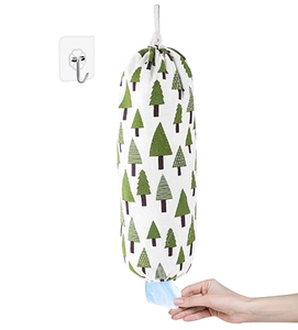 Detail of a wall-mounted plastic bag organizer with green tree pattern and bottom dispenser