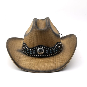 Detail of straw cowboy hat featuring blue rhinestones and silver star metal badge