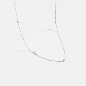 Detail of silver chain necklace featuring a V-shaped pendant and sparkling round diamonds