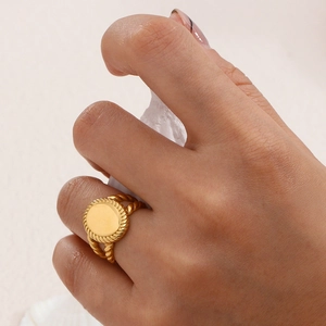 Detailed view of an 18K gold plated oval ring with a woven rope textured band on finger