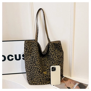 Detail of leopard print canvas tote bag with large capacity next to a magazine